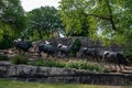 Dallas, Texas - May 7, 2018: Cowboy and longhorn cows with cattle in the background, as part of a landmark bronze cattle