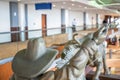 Dallas, Texas, US - 10.2022 - Statue of a cowboy running cattle in the DFW airport rental car facility