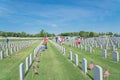 Volunteers and family members place flags on fallen heroes heads