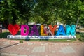 18.06.2022. Dalyan. Turkey. A beautiful girl in a dress and a hat near the word Dalyan.