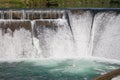 Dam in forest. Water flowing over small waterfall. Water stream and foam. Water energy. Rural dike. Countryside weir. Royalty Free Stock Photo