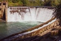 Dam in forest. Water flowing over small waterfall. Water stream and foam. Water energy. Rural dike. Countryside weir. Royalty Free Stock Photo