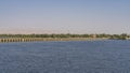 The dam of the sluice system crosses a wide, calm river.