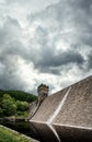 Dam wall with stone overflow tower and green forest in background reflecting in river water below old Peak District reservoir Royalty Free Stock Photo