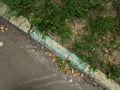 Damadged old curb painted aquamarine needs to be replaced. Yellow leaves on asphalt. Top view Royalty Free Stock Photo