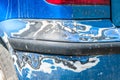 Damage on blue scratched car bumper with damaged and peeled paint in crash accident or parking lot Royalty Free Stock Photo