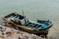 Damage fishing boat moored to rock pier Royalty Free Stock Photo