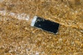 Damage smartphone dropped wet water on flooding of ocean Royalty Free Stock Photo