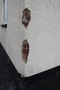 Damage to house rendering revealing brickwork underneath render Royalty Free Stock Photo