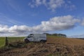 A damaged and abandoned White Van parked in a ploughed field near to Montrose