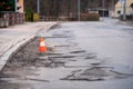 Damaged asphalt pavement road with potholes and traffic cone Royalty Free Stock Photo