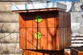 Damaged bee hive hidden in a park in winter sunny day.