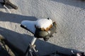 Damaged bicycle saddle under the snow. The cover of the sit  is ragged, gel padding sticking out.  The bike is not used in winter Royalty Free Stock Photo