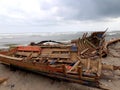 Damaged Boat Hit by Waves Stranded on the beach Royalty Free Stock Photo
