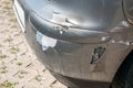 Damaged and broken car bumper with scratched paint in the accident or collision in the traffic or parking lot