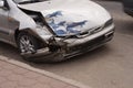 Damaged car with front end smashed after a crash accident parked on the street