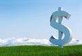 Damaged concrete dollar sign statue isolated on grass meadow with snowy mountain and blue sky as background