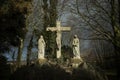 .Damaged concrete statues of Jezus on a cross with Mary and Joseph next to him