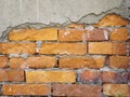 Damaged concrete wall with red bricks exposed. Royalty Free Stock Photo