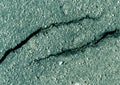 Damaged cyan toned asphalt surface. Royalty Free Stock Photo