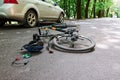 Damaged equipment. Bicycle and silver colored car accident on the road at forest at daytime Royalty Free Stock Photo