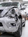 Damaged front left side of a silver suv after collision in a garage setting Royalty Free Stock Photo