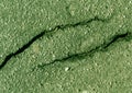 Damaged green toned asphalt surface.