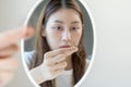Damaged hair, face worried asian young woman, girl look into mirror, holding hair loss and show hairfall on her hand after hair Royalty Free Stock Photo