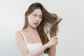 Damaged Hair, frustrated asian young woman, girl hand in holding brush splitting ends messy while combing hair, unbrushed dry long Royalty Free Stock Photo