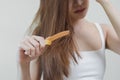 Damaged Hair, frustrated asian young woman, girl hand in holding brush splitting ends messy while combing hair, unbrushed dry long Royalty Free Stock Photo