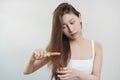 Damaged Hair, frustrated asian young woman, girl hand in holding brush splitting ends messy while combing hair, unbrushed dry long Royalty Free Stock Photo