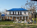 Damaged house with blue tarps on the roof and debris after Hurricane Katrina