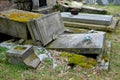 damaged old graves. tombstones fallen to the side sunken and laid.