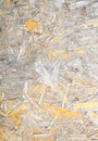 Damaged Oriented Strand Board. Wooden panel made from pressed sandy brown wood shavings as background closeup Royalty Free Stock Photo