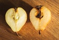 Damaged pears on wooden table. Peas with maggot on cutting board. Good and bad. Autumn farming. Difference concept.