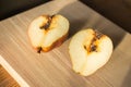 Damaged pears on wooden table. Peas with worm on cutting board. Juicy fruits. Autumn farming. Autumn harvest.