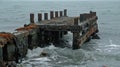 A damaged pier protruding out of a murky debrisfilled ocean