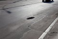 Damaged road, cracked asphalt blacktop with potholes and patches, Ukraine. Very bad tarmac road with big holes. Terrible Royalty Free Stock Photo