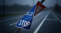 Damaged Road Sign with Yield and Stop Instructions in Blurry Road Scene Royalty Free Stock Photo