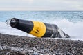 Damaged sea buoy cardinal danger mark washed ashore after a storm Royalty Free Stock Photo