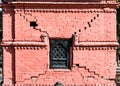 Damaged shrine in Pashupatinath diagonal shear cracks running from window\'s corners in unreinforced brick masonry