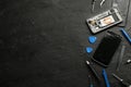 Damaged smartphone and repair tools on black background, flat lay. Space for text Royalty Free Stock Photo