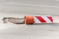 Damaged street reconstruction or construction barricade caution red and white sign cover the open hole of manhole on the road as a Royalty Free Stock Photo