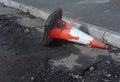 Damaged traffic cone in gutter, road undergoing repairs Royalty Free Stock Photo