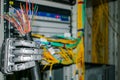 Damaged utp cable is in the robot`s hand. A mechanical robot arm holds a damaged Internet cable in the data center server room