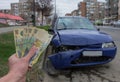 Damaged vehicle after car accident parked on the roadside. Car insurance concept with Romanian money lei Ã¢â¬â the cost of car Royalty Free Stock Photo