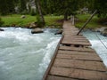 Damaged wooden bridge over a flooded stream Royalty Free Stock Photo