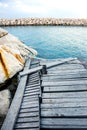 Damaged wooden pier with rock