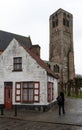 Damme, Flemish Region - Belgium - Tower of a medieval rectangular church and a vintage farmer house Royalty Free Stock Photo