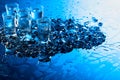 Damp glasses of vodka with ice on a black reflective background Royalty Free Stock Photo